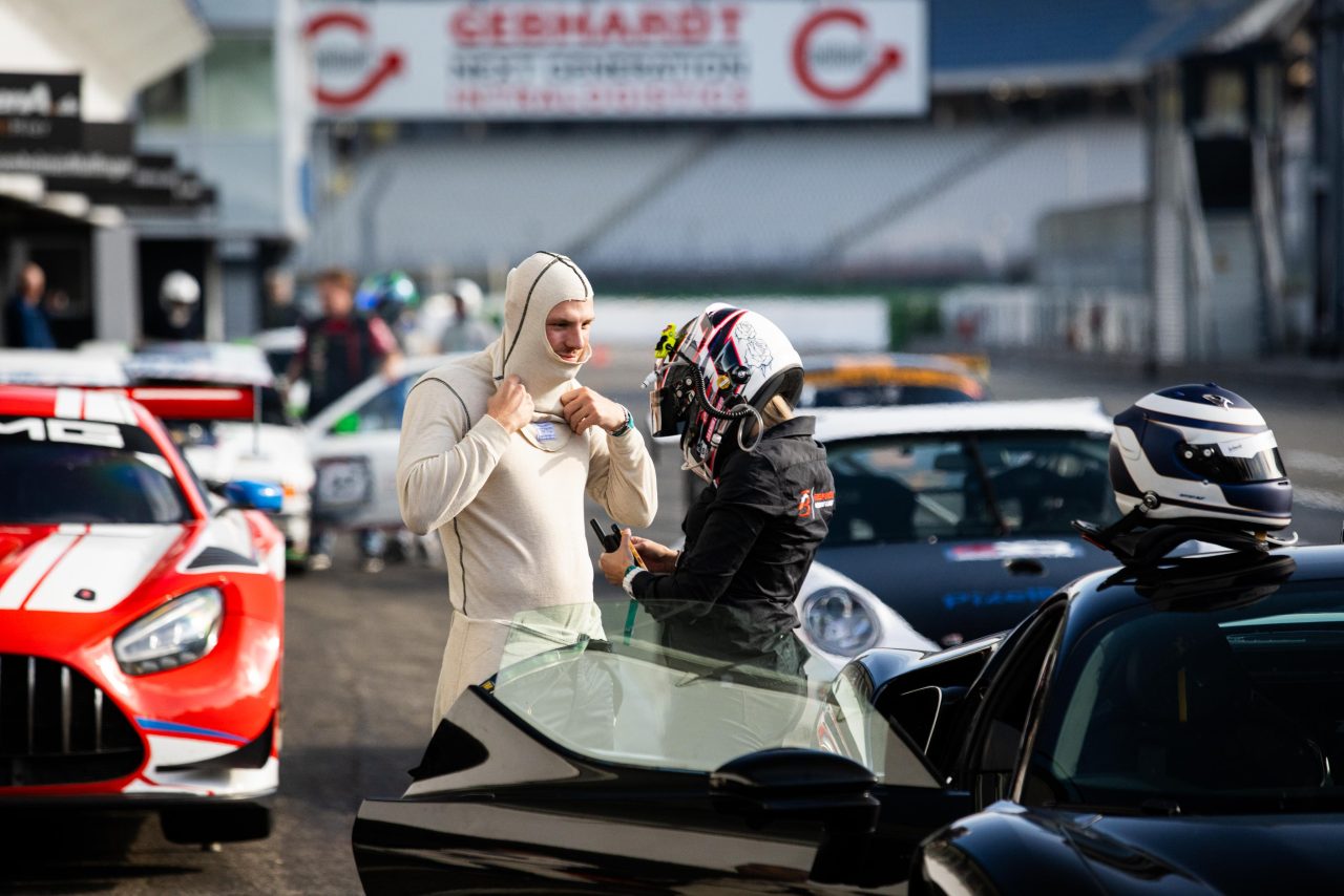 Trackday mit Fredy Barth - Fahrer in Rennanzügen und Sportautos in der Boxengasse