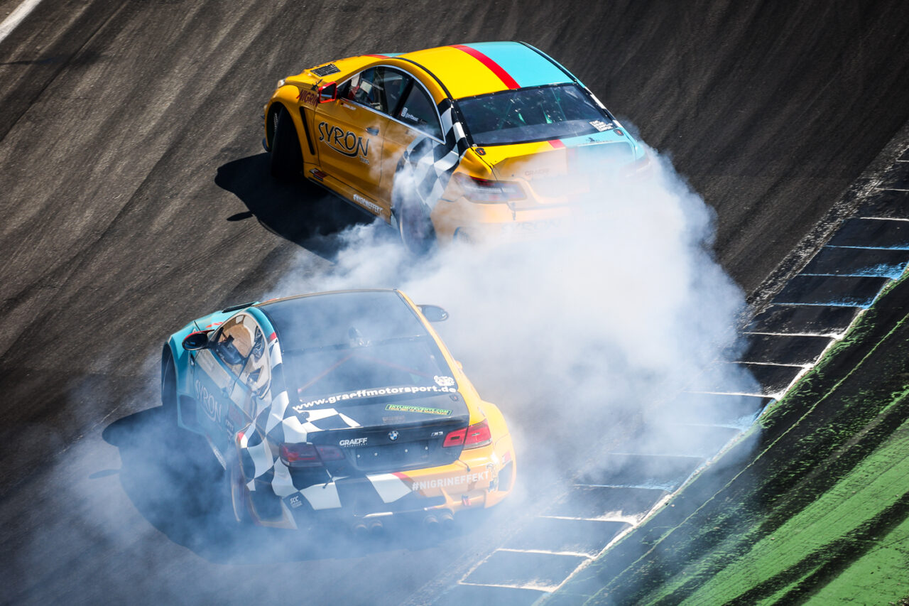 zwei parallel driftende Autos in der Sachs-Kurve